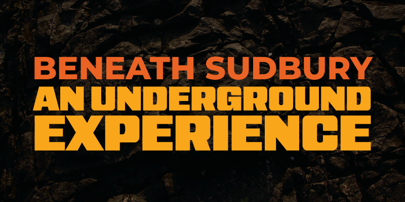 Bold orange text reading “Beneath Sudbury: An Underground Experience” on a dark background of textured rock, evoking a mining environment.